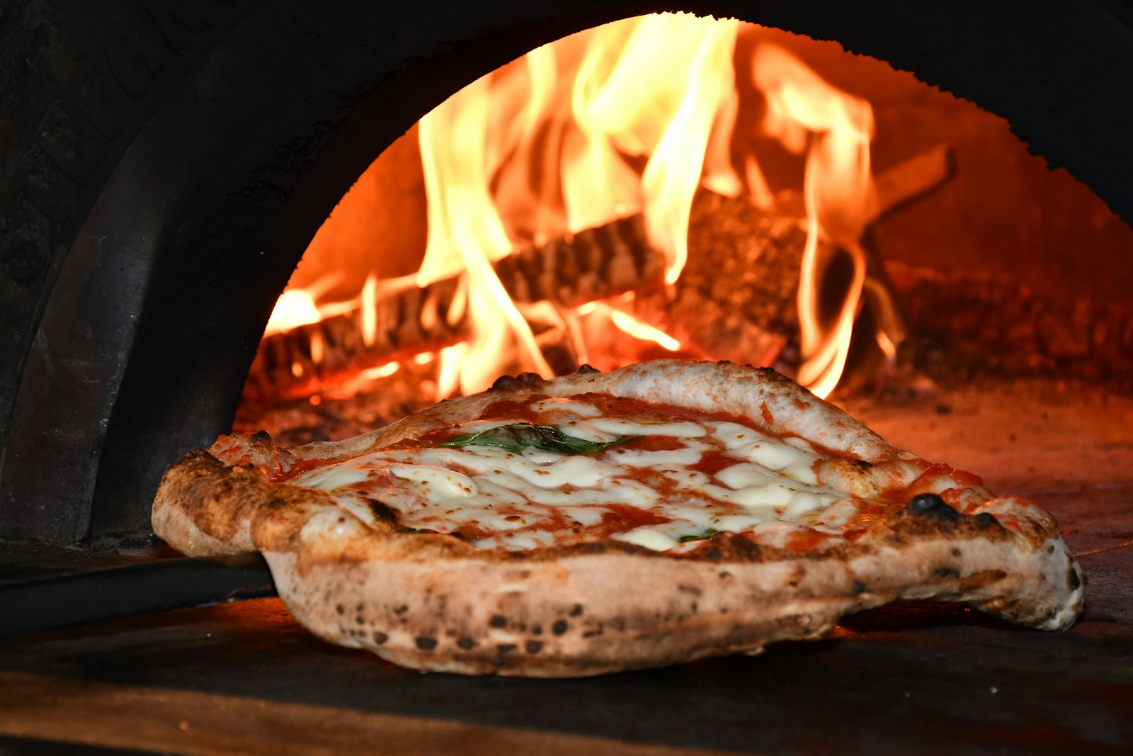 Pizza assando dentro do forno a lenha